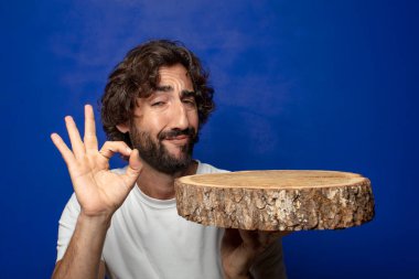 Genç, sakallı, ahşap kopya alanı olan bir adam.