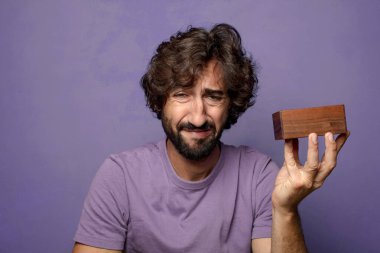 Genç, sakallı, gizemli kutulu bir adam.