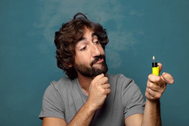 Genç, sakallı ve çakmaklı bir adam.