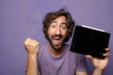 Genç, sakallı, dokunmatik ekranı tutan bir adam.