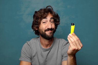 Genç, sakallı ve çakmaklı bir adam.