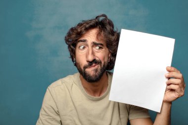 Genç, sakallı, elinde kağıt olan bir adam.