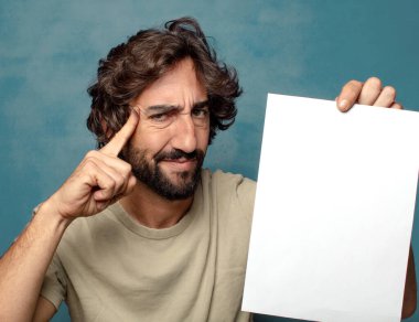 Genç, sakallı, elinde kağıt olan bir adam.