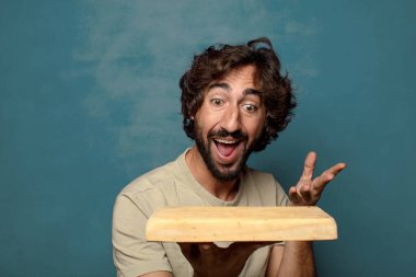 Boş tahta kesim masası olan genç, sakallı bir adam.