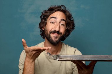 Gümüş tepsisi olan genç, sakallı bir adam.