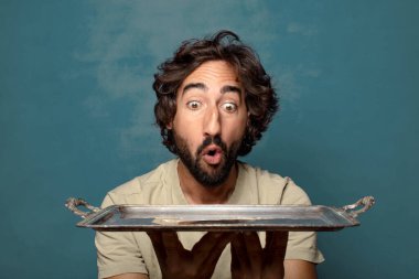 Gümüş tepsisi olan genç, sakallı bir adam.