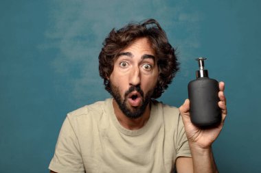 Sabun makinesi olan genç, sakallı bir adam.