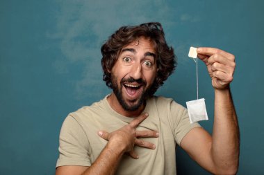 Genç, sakallı, çay içen bir adam.