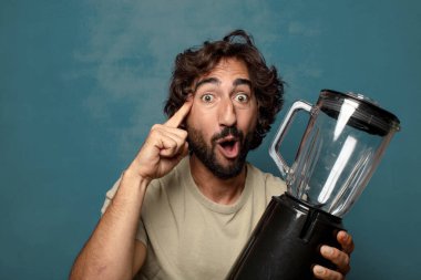 Genç, sakallı, blender makineli bir adam.