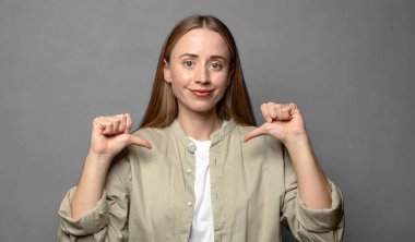 Gururlu, kibirli ve kendinden emin, tatmin olmuş ve başarılı görünüyor, kendini işaret ediyor.