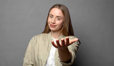 Gülümsüyor, mutlu görünüyor, kendinden emin ve arkadaş canlısı, anlaşmayı bitirmek için el sıkışmayı teklif ediyor, işbirliği yapıyor.