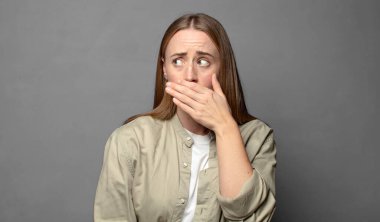 Şok olmuş, şaşırmış bir ifadeyle ağzı kapalı, sır saklayan ya da 