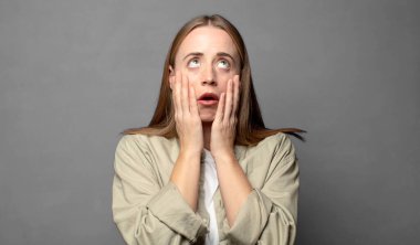 Şok olmuş ve korkmuş hissediyorum, yanaklarındaki ellerden sıkılmış gibiyim.