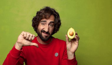 Avokadosu olan sakallı genç bir adam.