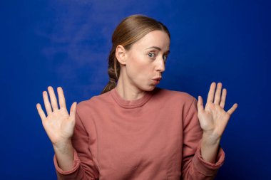 Sarışın kadın gergin, endişeli ve endişeli görünüyor. Benim hatam olmadığını söylüyor. Yoksa ben yapmadım.