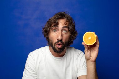 Portakal dilimli sakallı genç bir adam.