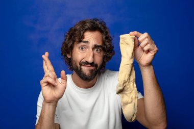 Kirli çorabı olan genç, sakallı bir adam.