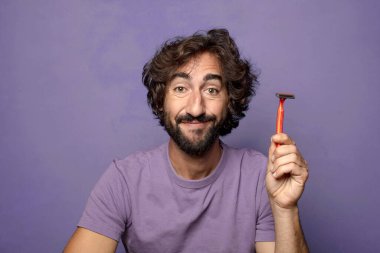 Traş makinesi olan genç, sakallı bir adam.