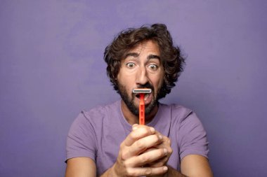 Traş makinesi olan genç, sakallı bir adam.