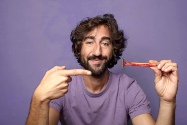 Traş makinesi olan genç, sakallı bir adam.