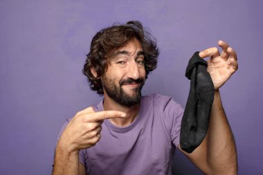 Kirli çorabı olan genç, sakallı bir adam.