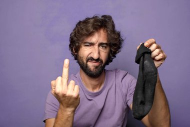 Kirli çorabı olan genç, sakallı bir adam.