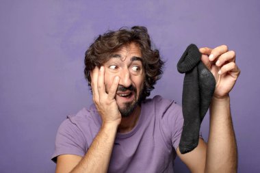 Kirli çorabı olan genç, sakallı bir adam.