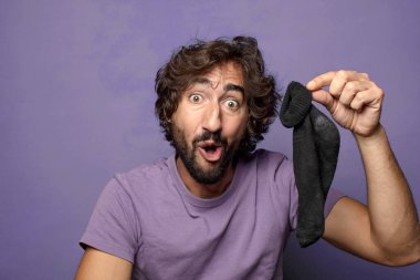 Kirli çorabı olan genç, sakallı bir adam.