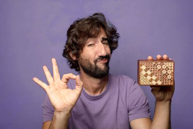 Genç, sakallı, gizemli kutulu bir adam.