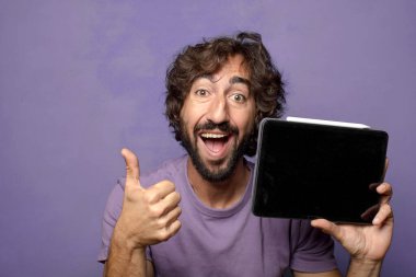 Genç, sakallı, dokunmatik ekranı tutan bir adam.