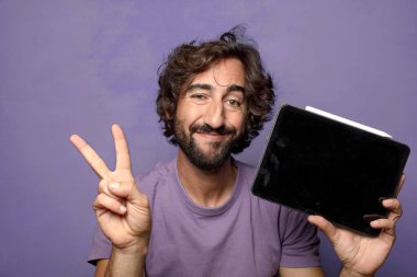 Genç, sakallı, dokunmatik ekranı tutan bir adam.