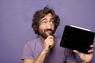 Genç, sakallı, dokunmatik ekranı tutan bir adam.