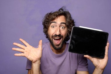 Genç, sakallı, dokunmatik ekranı tutan bir adam.