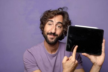 Genç, sakallı, dokunmatik ekranı tutan bir adam.