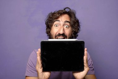 Genç, sakallı, dokunmatik ekranı tutan bir adam.