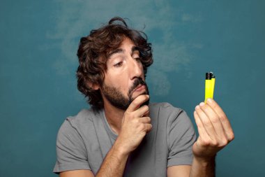 Genç, sakallı ve çakmaklı bir adam.