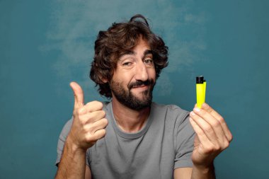 Genç, sakallı ve çakmaklı bir adam.