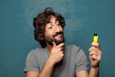 Genç, sakallı ve çakmaklı bir adam.