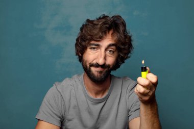 Genç, sakallı ve çakmaklı bir adam.