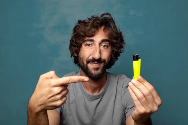 Genç, sakallı ve çakmaklı bir adam.