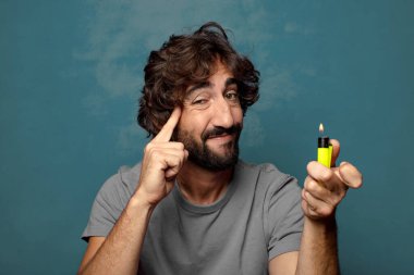 Genç, sakallı ve çakmaklı bir adam.