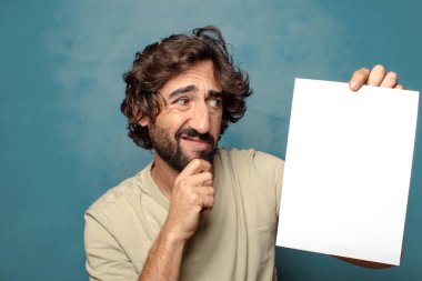 Genç, sakallı, elinde kağıt olan bir adam.