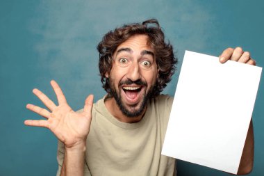 Genç, sakallı, elinde kağıt olan bir adam.