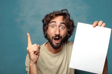 Genç, sakallı, elinde kağıt olan bir adam.