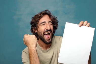 Genç, sakallı, elinde kağıt olan bir adam.