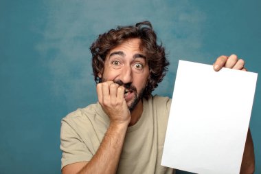 Genç, sakallı, elinde kağıt olan bir adam.