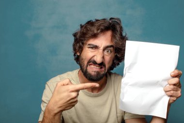 Genç, sakallı, elinde kağıt olan bir adam.