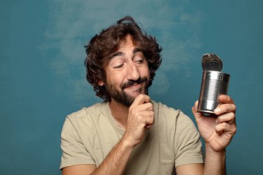 Genç, sakallı, çelik tenekeli adam.