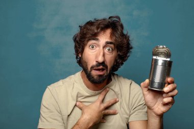 Genç, sakallı, çelik tenekeli adam.