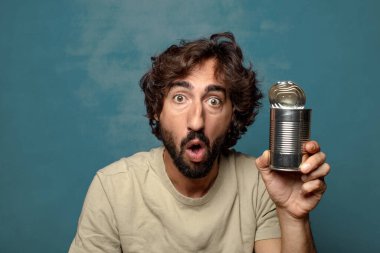 Genç, sakallı, çelik tenekeli adam.